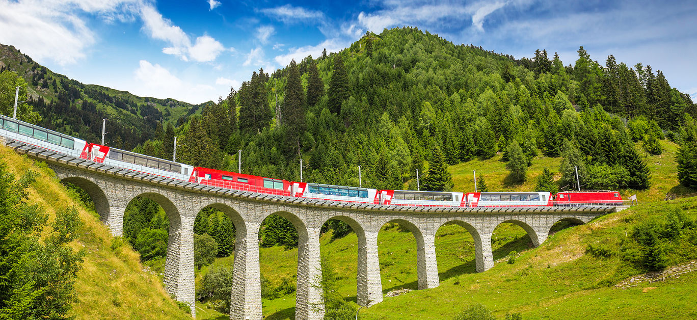 A view of a luxurious train traveling through the Swiss Alps.